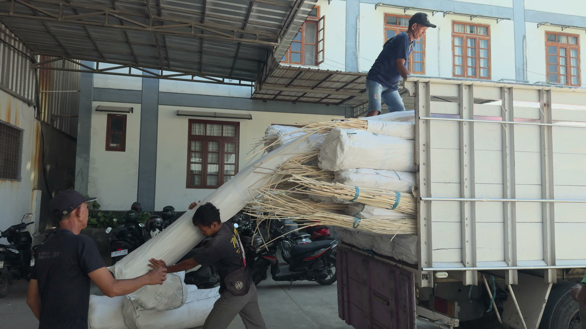Workers loading protected rattan goods for shipment